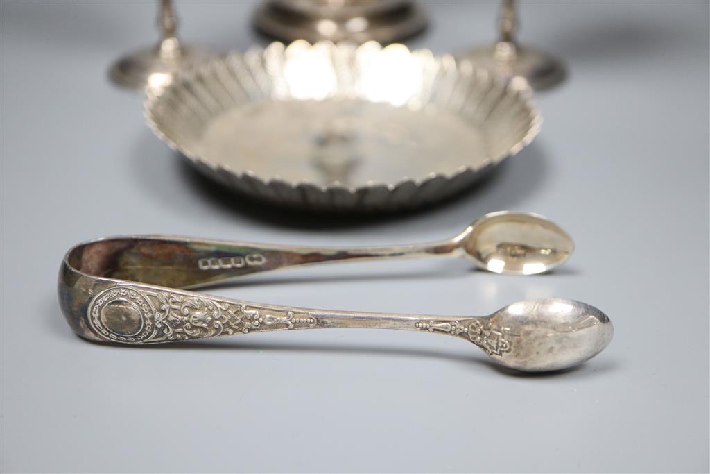 A pair of modern silver goblets, a silver candlestick, modern silver dis and pair of silver sugar tongs,